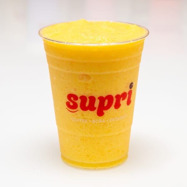 A clear plastic cup filled with a bright yellow Supri mango smoothie, against a white background.
