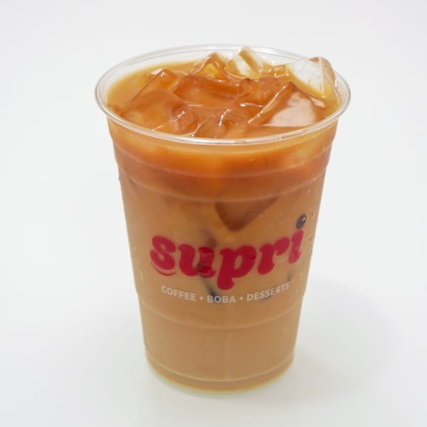 Iced coffee in a clear plastic cup with the red "Supri" logo on a white background.