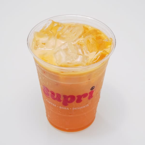 Iced Thai tea with a creamy top layer in a clear plastic cup with the Capri logo.
